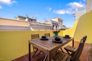a wooden table with chairs and flowers on a balcony at Soho Garden Old San Juan in San Juan +9 photos