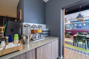 a restaurant with a counter with a coffee maker at Holiday Inn Express Aberdeen Airport by IHG in Dyce