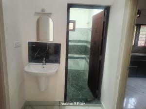 JāmbにあるKOYICKAL Apartmentsの洗面台と鏡のあるバスルーム