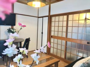a living room with a vase of flowers on a table at HOKUSAI-KAN Osaka Taisho in Osaka