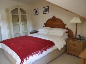 1 dormitorio con 1 cama grande con manta roja en Chilgrove Farm Bed & Breakfast, en Chilgrove