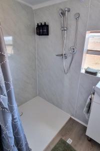 a shower in a bathroom with a shower head at Quentin Park Hideaway in Peterborough