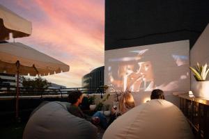 a group of people sitting in front of a large screen at Little Drifter Canberra in Canberra
