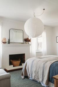 una camera con letto, specchio e camino di Millingtons House a Orford