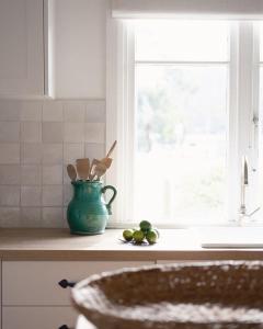 un bancone da cucina con un vaso verde e un po' di frutta di Millingtons House a Orford
