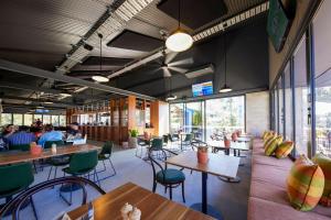 a restaurant with tables and chairs and people at Coomera Lodge Hotel in Gold Coast