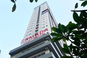 Un palazzo alto con un cartello sopra. di Ramada by Wyndham Serpong a Serpong