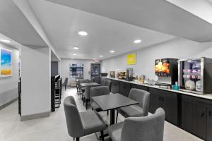 a waiting room with tables and chairs and a bar at Days Inn by Wyndham San Antonio Near Lackland AFB in San Antonio
