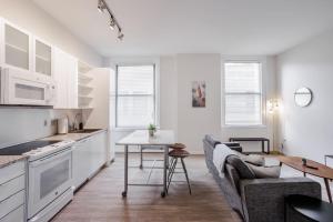 a kitchen and living room with a couch and a table at CozySuites Sky Central #3 in Cincinnati +8 photos