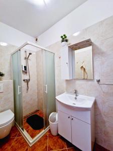 a bathroom with a shower and a sink and a toilet at Comfortable Rooms - City Place in Split +21 photos
