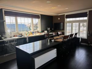 a kitchen with a table and chairs and windows at BIEI TERRACE 2nd Floor - 2F専用独立玄関 - 2F占有127平米2LDK - 大型バスルーム, 85型スマートTV, 無料Wi-Fi -駅前通り景観条例指定地区 in Biei