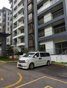 a white van parked in a parking lot in front of a building at 4H Guesthouse Cameron Highland in Brinchang