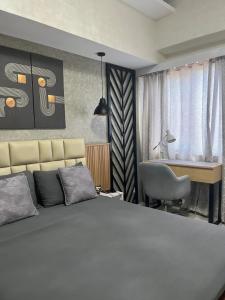 a bedroom with a bed and a desk and a chair at Happy City Pad at Be Residences Lahug in Cebu City
