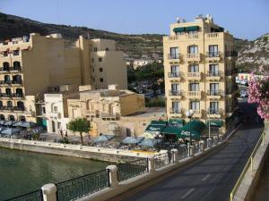 a city with buildings and a body of water at Hotel San Andrea in Xlendi