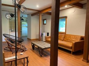 上山市A private inn where you can relax in nature and enjoy with groups of up to 14 people的带沙发和桌子的客厅