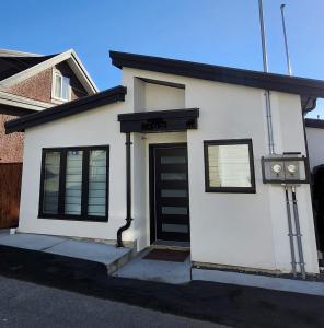 バンクーバーにあるCentral & Modern Whole House in Vancouverの黒い扉の小さな白い家