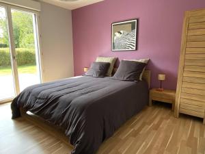 a bedroom with a bed with a purple wall at Grande maison au centre de Perros-Guirec avec jardin, terrasse et WIFI - FR-1-368-460 in Perros-Guirec