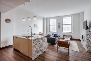 a kitchen with a sink and a living room at CozySuites Sky Central #6 in Cincinnati +8 photos