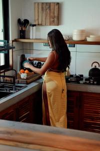 a woman standing in a kitchen preparing food at Casa Malia Siargao in General Luna +42 photos