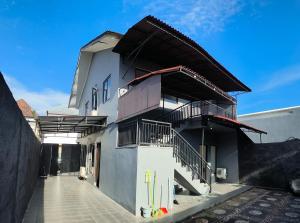 a white building with a staircase and a balcony at Kubu Jimbaran in Jimbaran