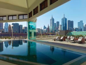 a swimming pool with a view of the city at The Langham Melbourne in Melbourne