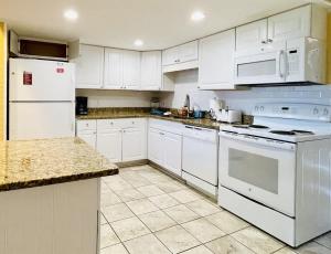 eine Küche mit weißen Geräten und weißen Schränken in der Unterkunft OCEANFRONT HOUSE ON THE SAND 2 Kings 4br 4ba 1st Floor of Triplex SLEEP 12 PGP1 in Myrtle Beach