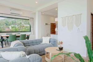 a living room with a blue couch and a table at v32A Blue Horizon Haad Yao, Seaview 3BR Apartment 1st Floor in Ko Phangan