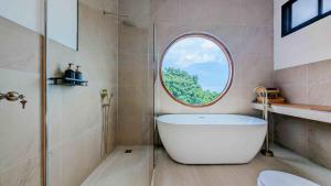 baño con bañera grande y ventana redonda en Blue Horizon Haad Yao, Seaview 3BR Apartment 1st Floor, en Ko Pha Ngan 68 fotos más