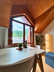 a dining room with a table and a large window at Apartamento Sobremonte vistas al Rio Gallego in Biescas