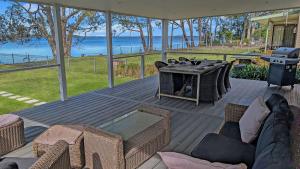 a patio with a table and chairs and a grill at Billyz Basin by Experience Jervis Bay in St Georges Basin