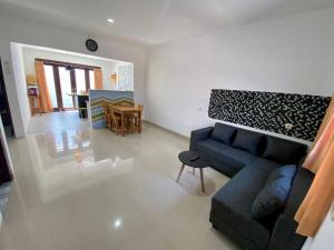 a living room with a blue couch and a table at Djanuraga House 6 in Darmasaba