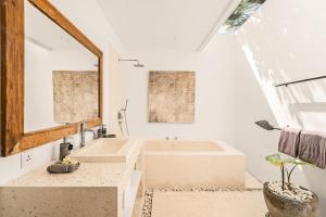 Un baño con dos lavabos y un espejo grande. en The Saya House Villa by Betterplace, en Kerobokan 9 fotos más