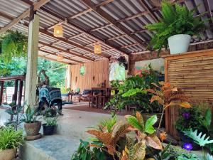 a conservatory with plants and a wooden ceiling at Spirit Mountain in Ban Nong Thale