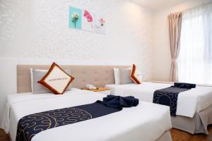 Postel nebo postele na pokoji v ubytování Saigon's Book Da Lat Hotel