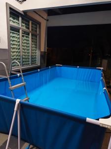 een blauwe pooltafel met een stoel op een balkon bij Ustazahhomestay in Bemban