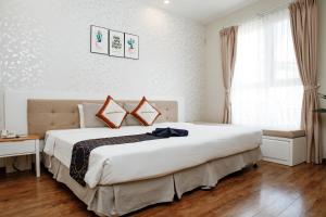 Postel nebo postele na pokoji v ubytování Saigon's Book Da Lat Hotel
