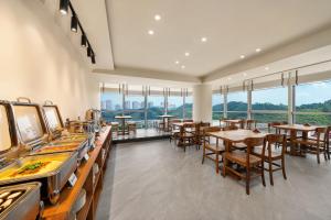Un restaurante con mesas y sillas y una fila de máquinas de pinball. en Leshan Yunzhong Yashe Private Hot Spring Hotel, en Leshan