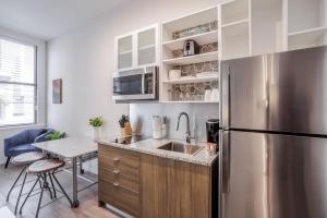 a kitchen with a stainless steel refrigerator and a table at CozySuites Sky Central #12 in Cincinnati +8 photos