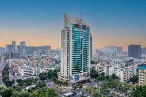 ein hohes Gebäude in einer Stadt mit vielen Gebäuden in der Unterkunft Orange Crystal Hotel, Shenzhen Bao'An Joy City in Shenzhen