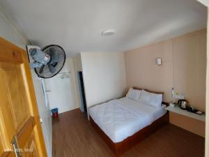 ein Schlafzimmer mit einem weißen Bett und einem Ventilator in der Unterkunft Coral Beach Loft-Simply Stay in Tioman Island