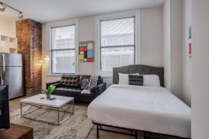 a bedroom with a large bed and a couch at CozySuites Sky Central #15 in Cincinnati