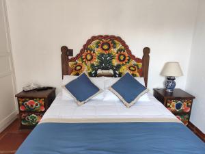 a bedroom with a large bed with two pillows at Casa de las Conchas Cuernavaca in Cuernavaca
