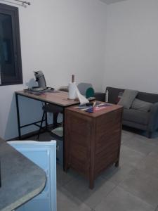a living room with a desk and a couch at Loc' Avirons 10 bis in Les Avirons