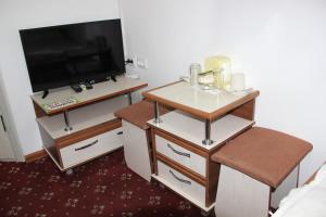 een kamer met een televisie en een tafel en stoel bij Sultan Kyzyl-Kiya 