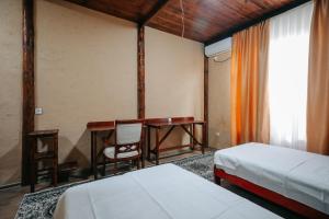 een kamer met een bureau en een tafel met 2 bedden bij Sultan Kyzyl-Kiya  +30 foto's