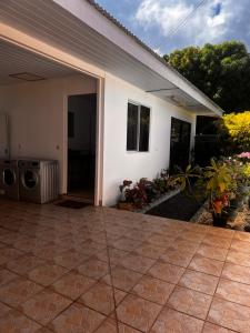 a white house with a patio with a washing machine at Studio Mohui RBNB in Punaauia