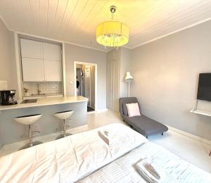a bedroom with a bed and a chair and a kitchen at Katas Suite, Helsinki city center in Helsinki