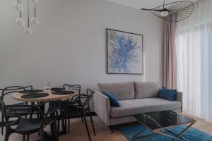 un salon avec un canapé et une table avec des chaises dans l'établissement Aparthotel Nad Zatoką- Apartament Elliot- Plaża Miejska, à Olsztyn