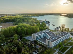 une vue aérienne d'un bâtiment à côté d'une masse d'eau dans l'établissement Aparthotel Nad Zatoką- Apartament Elliot- Plaża Miejska, à Olsztyn