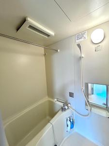 a bathroom with a bath tub and a shower at 关西机场直达 i Home Osaka URBAN NOOK 舒适双床房 天下茶屋站步行3分钟 in Osaka